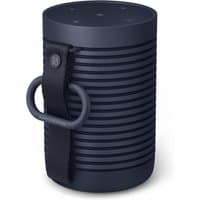 Navy cylindrical Bang & Olufsen BeoSound Explore speaker with vertical ridges and a black strap loop.