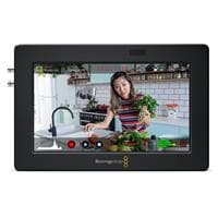 Blackmagic Design HYPERD/AVIDA03/5 Broadcast Monitor features a sleek black frame, a 5-inch display, and visible control buttons with a vibrant image of a woman cooking in a kitchen setting.