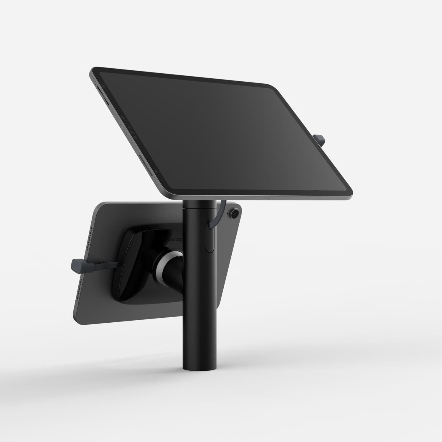 Black Bouncepad Core Twin tablet stand features a sleek design, adjustable angle, and compatibility with all USB-C devices, mounted on a sturdy pole.