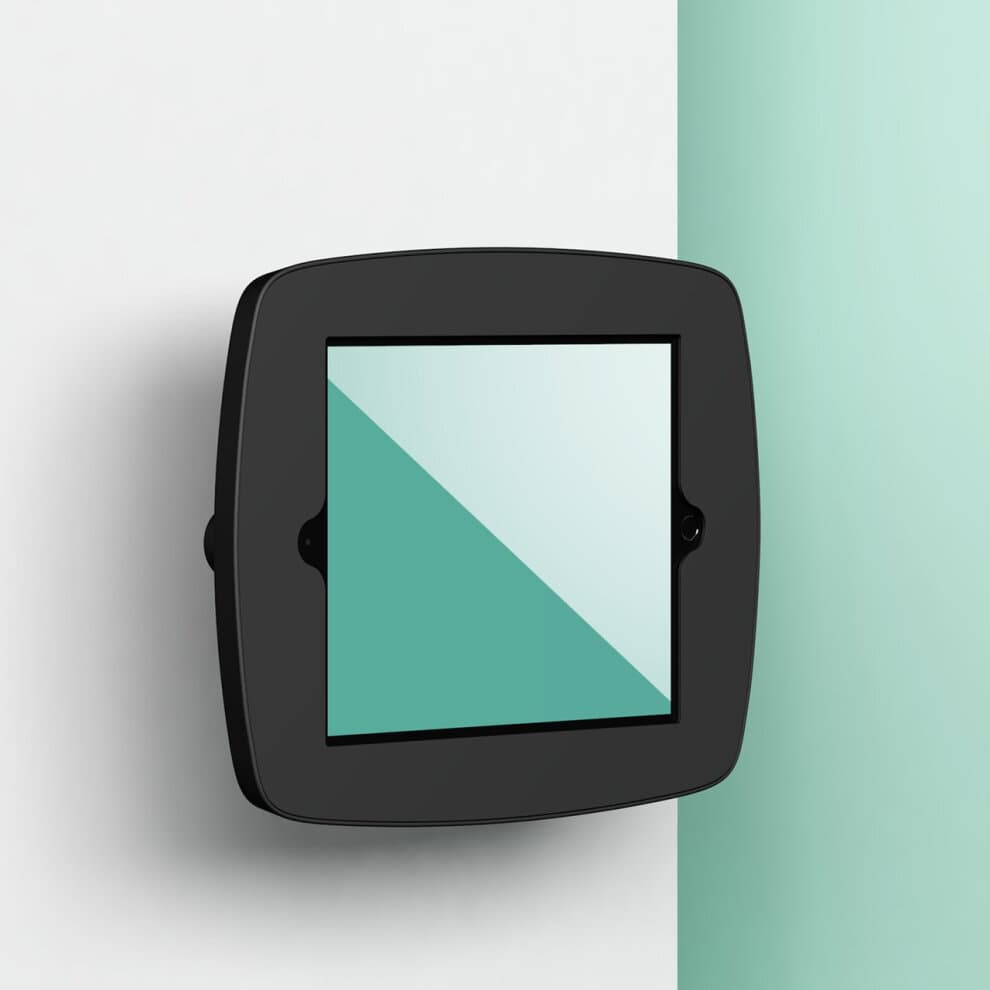 Black Bouncepad VESA mount for Samsung Galaxy Tab S3 9.7, featuring a sleek design with a glass front and a smooth finish, securely affixed to a light turquoise wall.