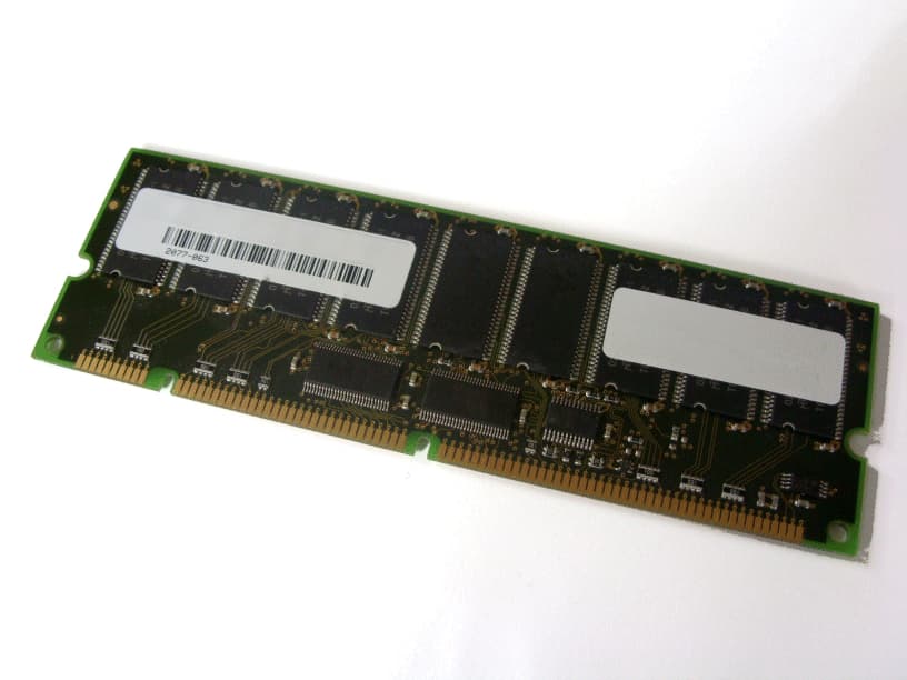 Green circuit board with a gold connector edge, featuring multiple black memory chips and two white labels, designed as a 256MB DIMM (PC100) memory module.