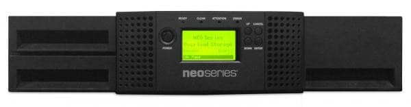 Black 2U tape storage device with a green LCD display, featuring 24 slots for LTO tapes, and ventilation grilles on the sides for cooling.