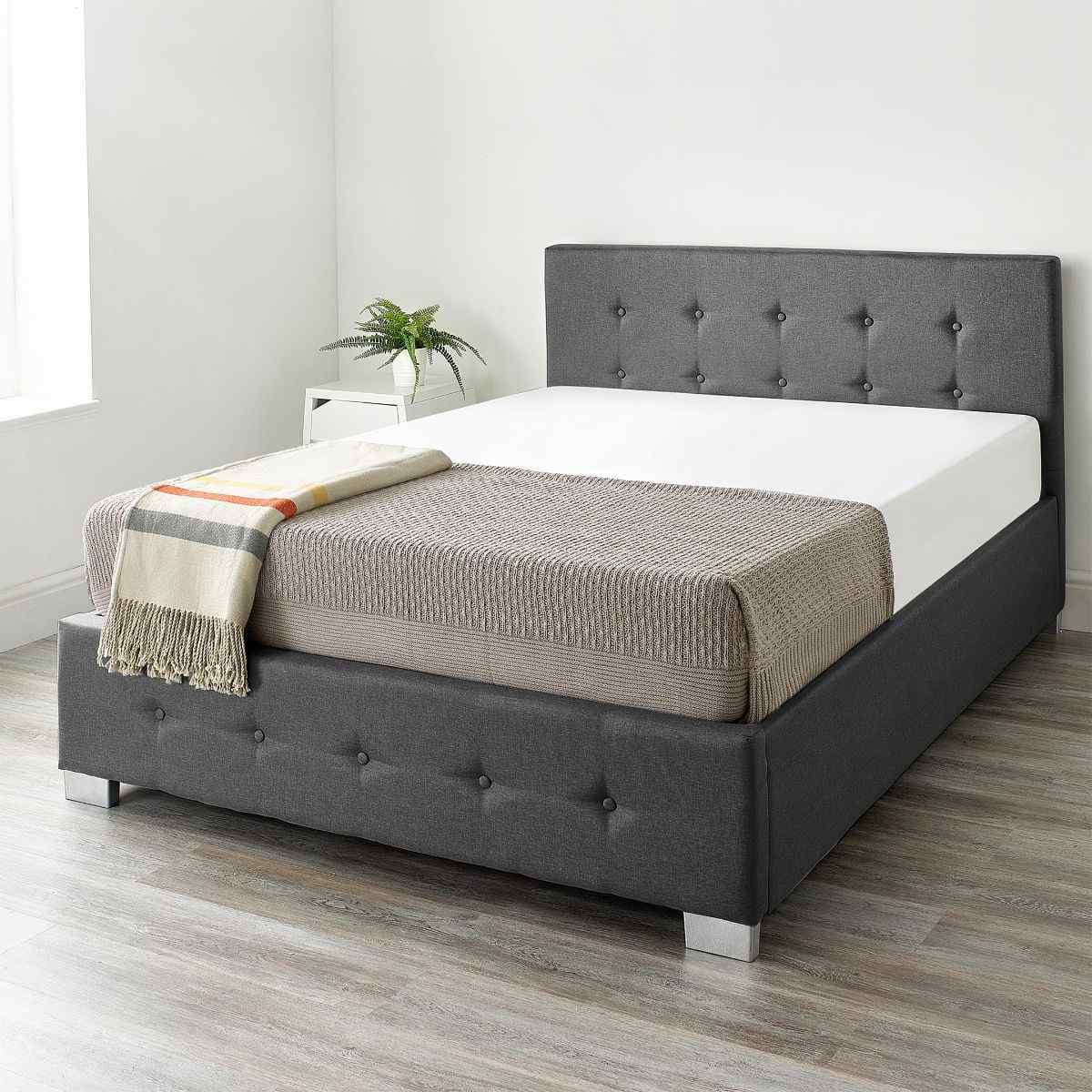 Aspire End Lift Ottoman Storage Bed in black linen, super king size, features a tufted headboard, spacious storage beneath, and sleek silver legs, set against a light room backdrop.