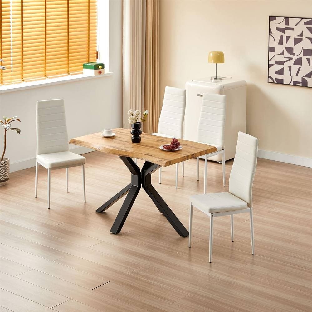 Wooden dining table with an X-shaped black metal base, featuring a natural brown top, accompanied by four white leather chairs in a bright, modern kitchen setting.
