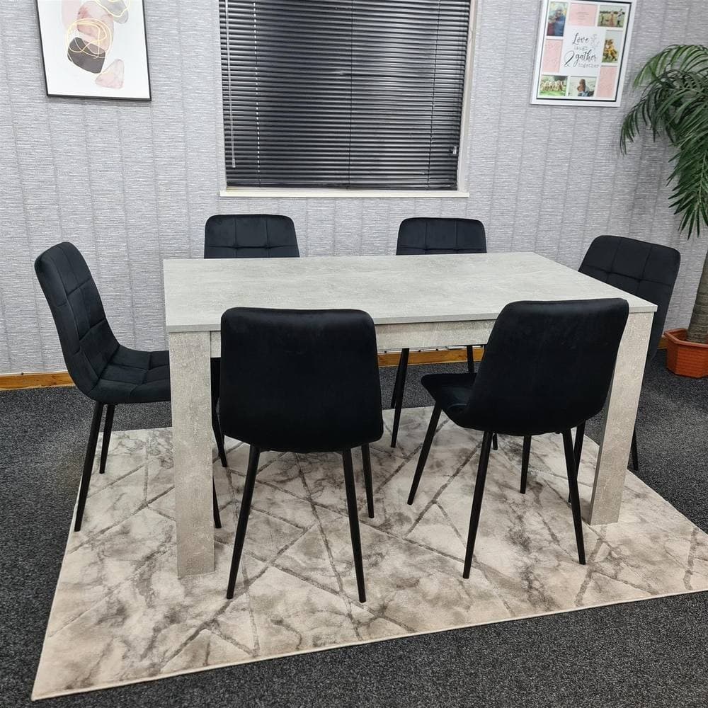 Grey dining table set with a rectangular table and six black upholstered chairs, featuring sleek legs and a modern design, placed on a patterned rug in a cozy room.