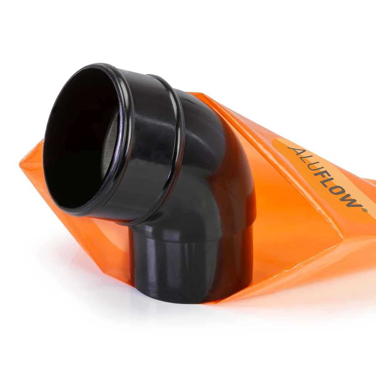 Black Aluflow downpipe offset bend with a smooth finish, featuring a curved design and a sturdy construction, displayed against an orange background.