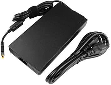 Black power adapter/inverter with a sleek rectangular design, featuring a detachable power cord and a connector for devices, labeled "CoreParts MBXLE-AC0006," rated at 230 W.