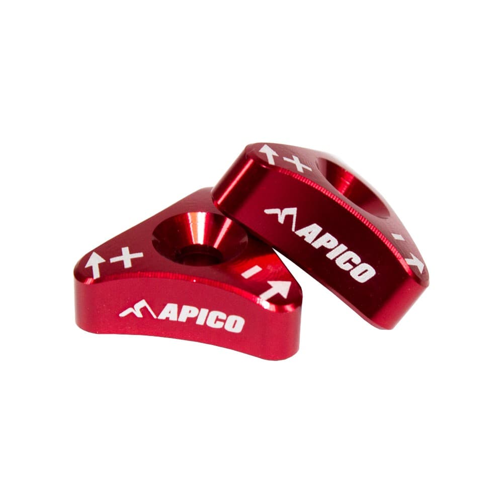 Red aluminum fork adjuster set by Apico, featuring a triangular shape with engraved directional arrows and the brand logo, designed for KTM, Husqvarna, Sherco, and Gas Gas WP forks (2006-2023).