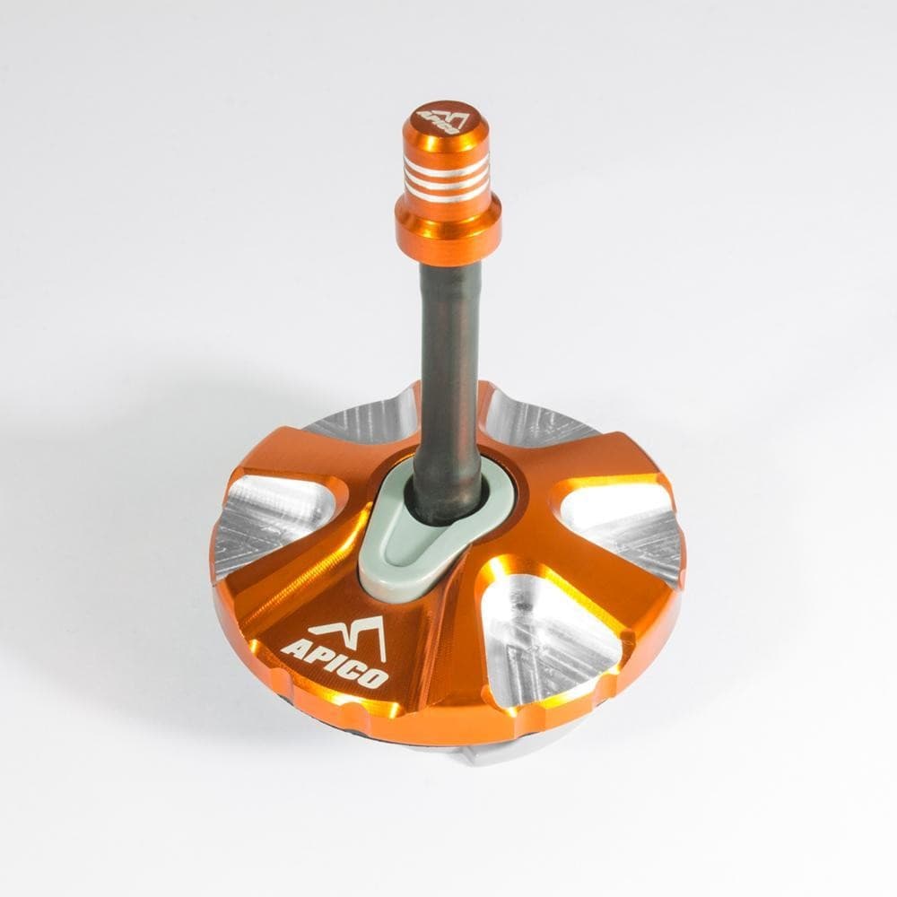 Apico alloy 1/4 turn fuel cap in vibrant orange with a silver accent, featuring a central black stem and the Apico logo, designed for KTM and Husqvarna motorcycles.
