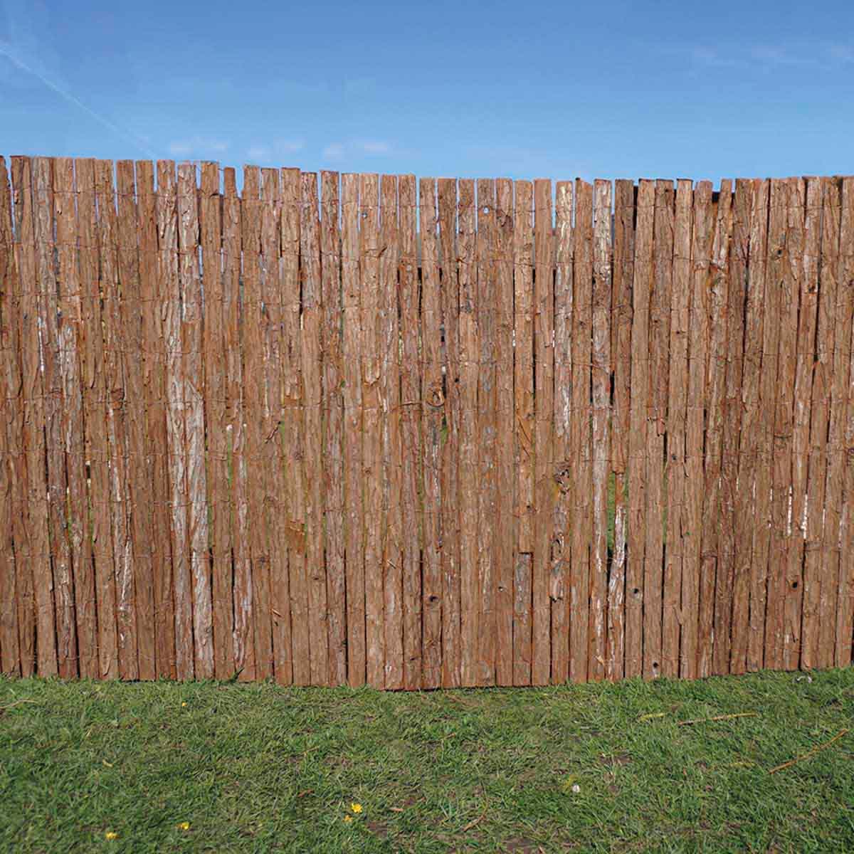 Brown bark screen roll made of natural wood, featuring vertical slats with a rustic texture, ideal for garden privacy and decoration against a clear blue sky.