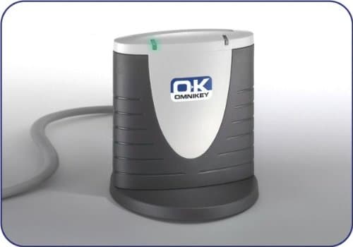 Gray and white USB2-connected smart card reader with a rounded design, featuring a green LED indicator and the Omnikey logo on the front.