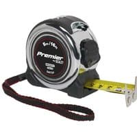 Black and silver Sealey tape measure with a yellow blade, rubber grip, and wrist strap, marked in meters and feet.