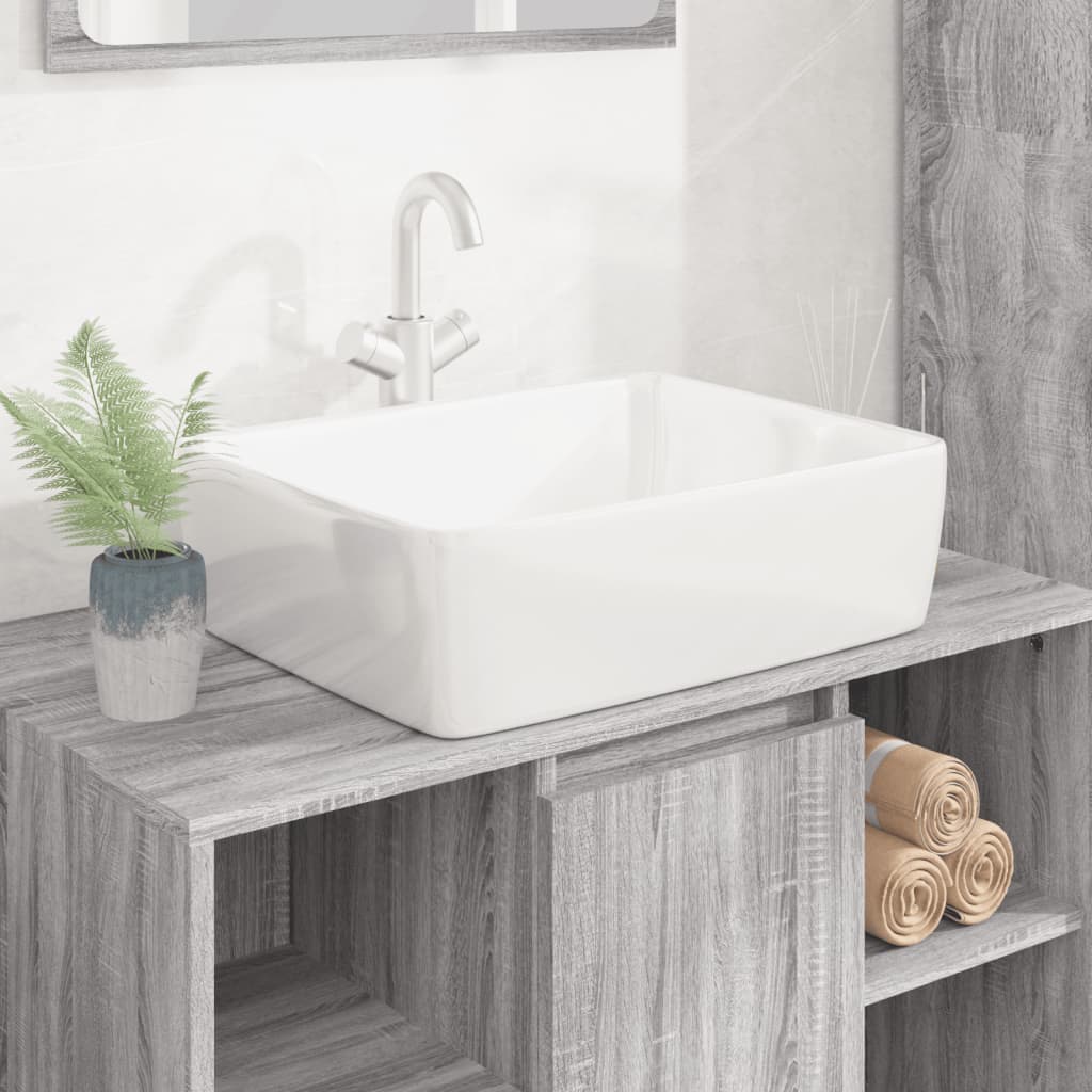 White ceramic rectangular wash basin measuring 18.9"x14.6"x5.1", featuring smooth edges, placed on a wooden vanity with a faucet and potted plant nearby.