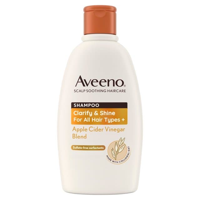 White plastic bottle with a brown flip-top lid, labeled "Aveeno Shampoo Clarify & Shine" featuring apple cider vinegar blend, 300ml, sulfate-free, suitable for all hair types.