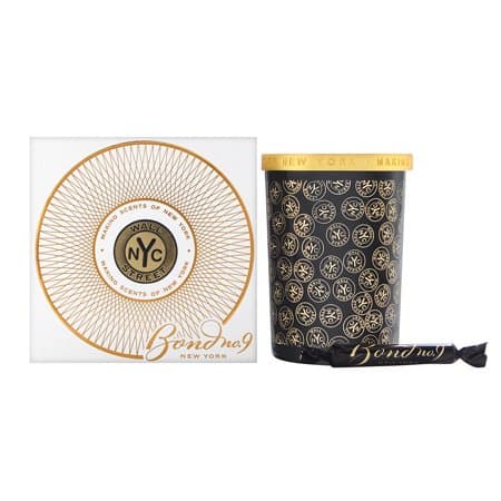 Black candle container with gold accents, featuring a decorative pattern and Bond No. 9 logo, alongside a white box with a circular gold design and the brand name.