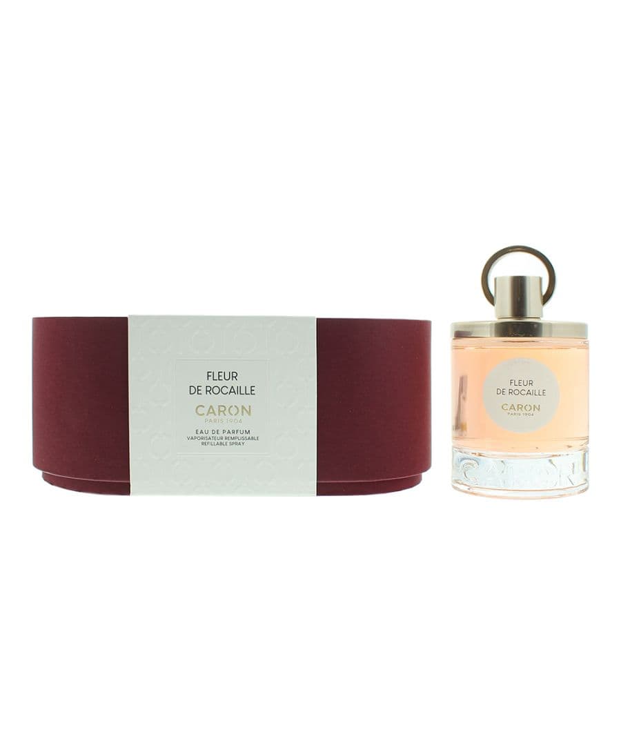 Caron Fleur De Rocaille Eau De Parfum 100ml features a clear glass bottle with a gold cap, placed beside a burgundy box with a white label displaying the product name.