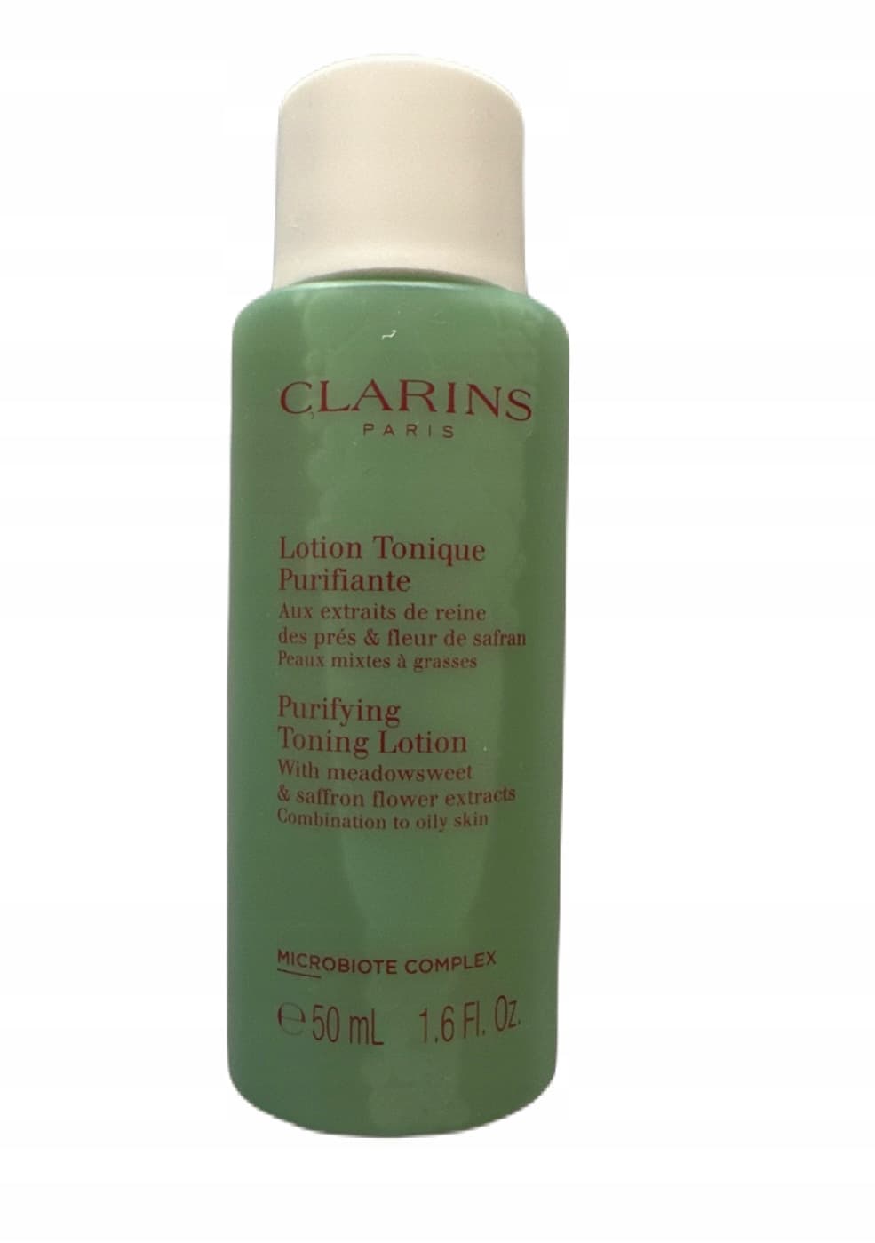 Green plastic bottle of Clarins Purifying Toning Lotion, 50 ml, featuring a white cap, with text highlighting its key ingredients and benefits for combination to oily skin.