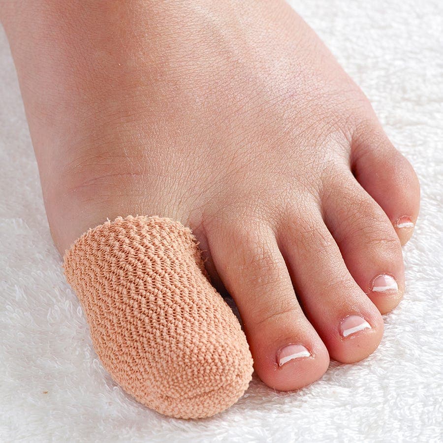 Light peach-colored SmartGel™ toe cap made of soft, stretchy material, snugly fitting over the tip of a bare toe, providing cushioning and protection.