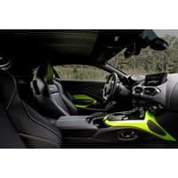 Black Aston Martin Vantage interior with neon green accents, sleek dashboard, and sporty bucket seats.
