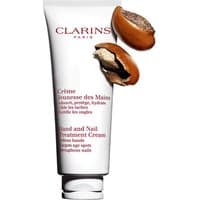 White Clarins Hand and Nail Treatment Cream tube with red text, featuring cracked shea nuts.