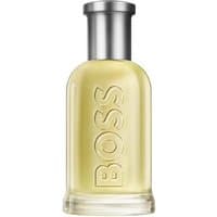 Clear glass bottle of Hugo Boss Bottled Eau de Toilette, embossed "BOSS," with silver cap, containing pale yellow liquid.