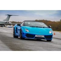 Blue Lamborghini supercar on a runway with a jet in the background, offered by Drivers Dream Days.