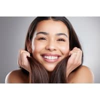 Smiling woman holding hair, promoting Rhinoplasty Treatment at Oak Tree Dental, Kirkintilloch on Wowcher.