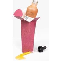UpCircle Organic Face Oil in a clear bottle with black dropper, pink box, and visible golden oil spill.