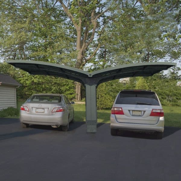 Grey metal double carport with a modern design, featuring a curved roof, accommodating two vehicles, set in a landscaped outdoor area with trees.