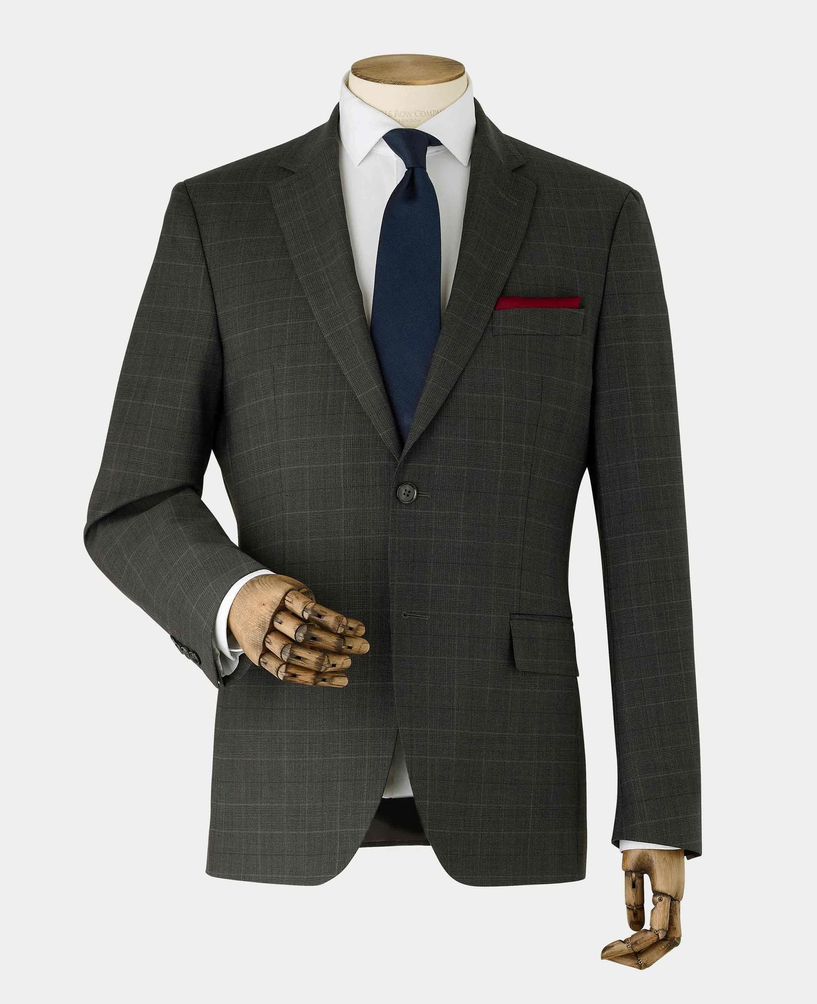 Men's grey Prince of Wales check suit jacket made from a wool blend, featuring a single button closure, notch lapels, and a red pocket square, displayed on a mannequin with a wooden hand.