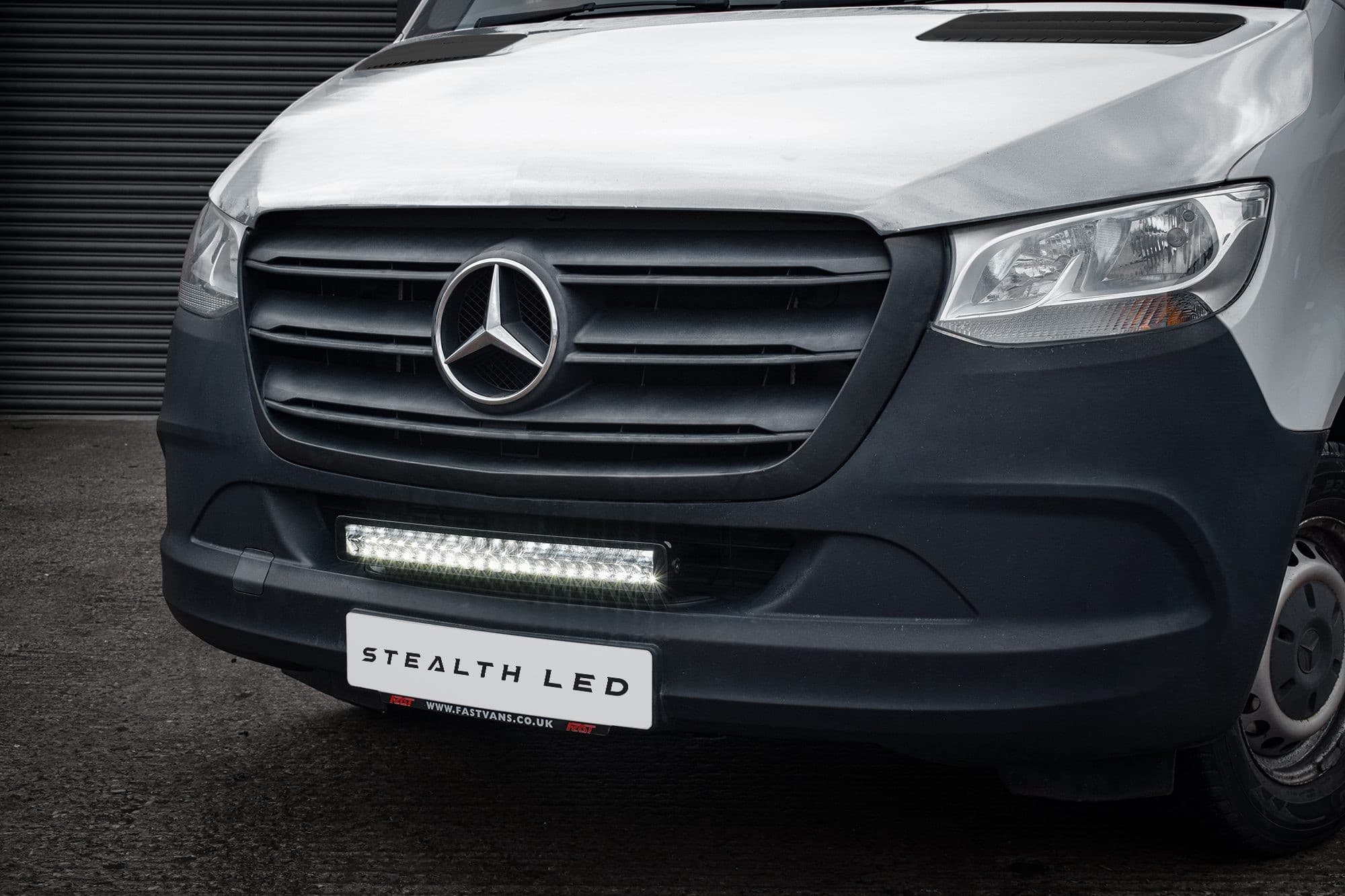Luminous LED integration grille kit for a 2019+ Mercedes Sprinter, featuring a sleek black grille with a bright white LED light bar beneath, showcasing a modern design.