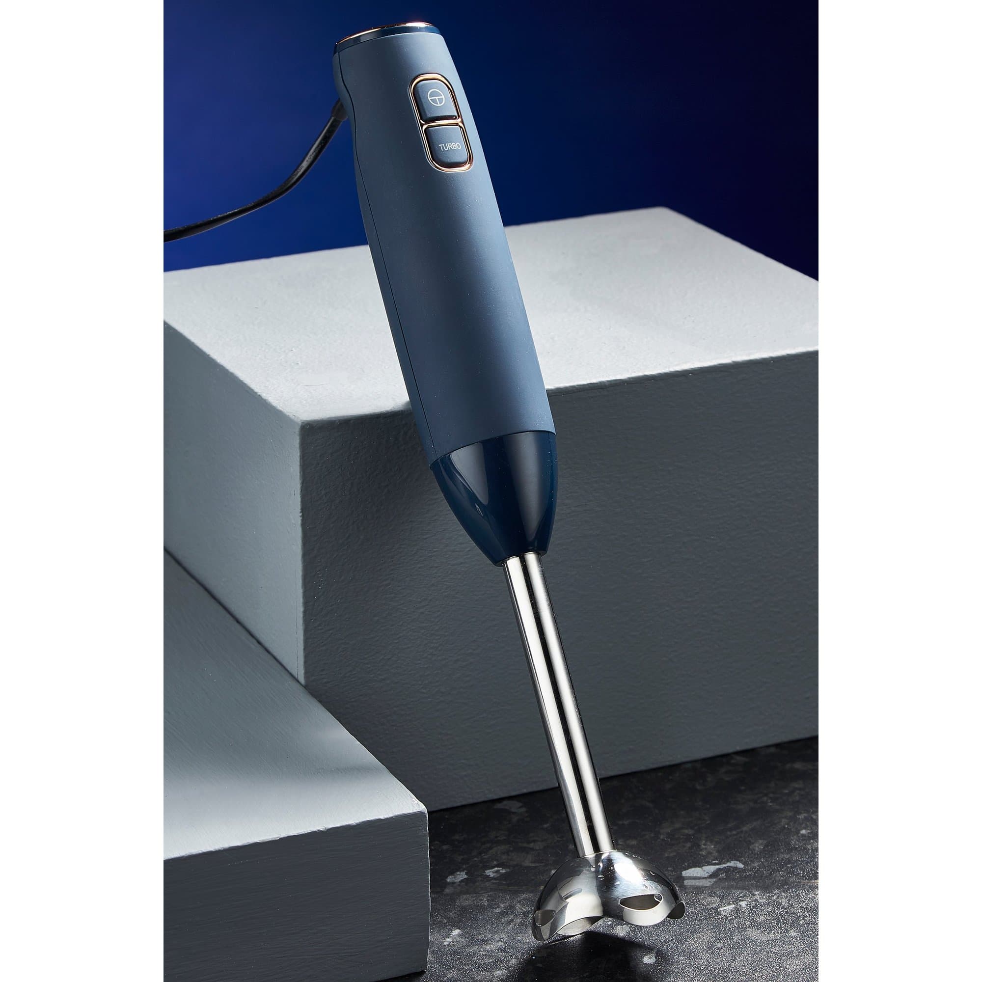 Blue Tower Cavaletto 600W stick blender with a sleek design, featuring a stainless steel blending shaft and two control buttons on the handle, placed on a textured surface.