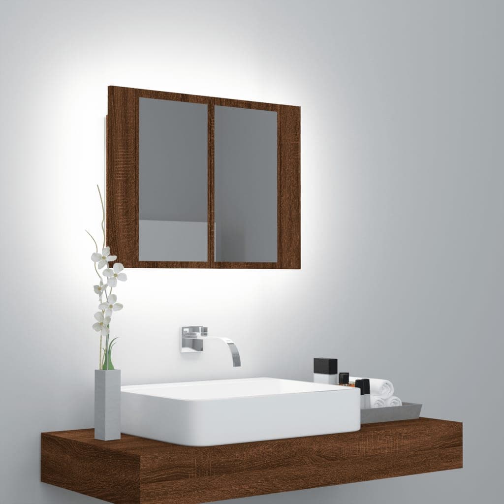 Brown oak LED mirror cabinet with two mirrored doors, mounted above a white sink, accompanied by decorative items like towels and a vase with flowers.