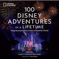 "Hardcover book '100 Disney Adventures of a Lifetime' with fireworks over a castle on the cover."