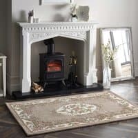Beige Shensi rug 120x180cm with intricate floral border and central medallion pattern on wooden floor by fireplace.