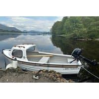 White motorboat with cabin, moored by Loch Awe, surrounded by trees and mountains, for hire from Portsonachan Hotel.