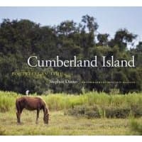 "Cumberland Island book cover featuring a horse grazing in a grassy field with trees in the background"