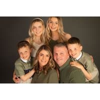 Family photoshoot package with smiling parents and four children, neutral backdrop, includes five printed photos.