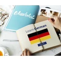 "Open book with German flag, text 'Learn German', and 'enter' button, next to a teal 'Wanderlust' magazine"