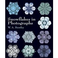 "Snowflakes in Photographs" book with intricate snowflake images on a dark background.