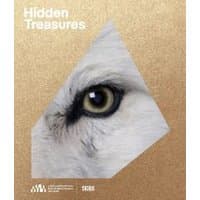 "The Hidden Treasures of the Natural History Museum Abu Dhabi" book with a wolf eye on a gold cover.