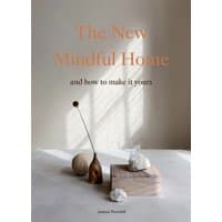 "The New Mindful Home" book with minimalist cover featuring vases and shadows on a white surface.