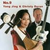 Yang Jing holds a traditional pipa, while Christy Doran stands beside her with a white electric guitar, both against a plain white background.