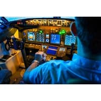 Flight simulator cockpit with illuminated control panels, screens, and pilot seat, Ascent Aviation, Linwood.