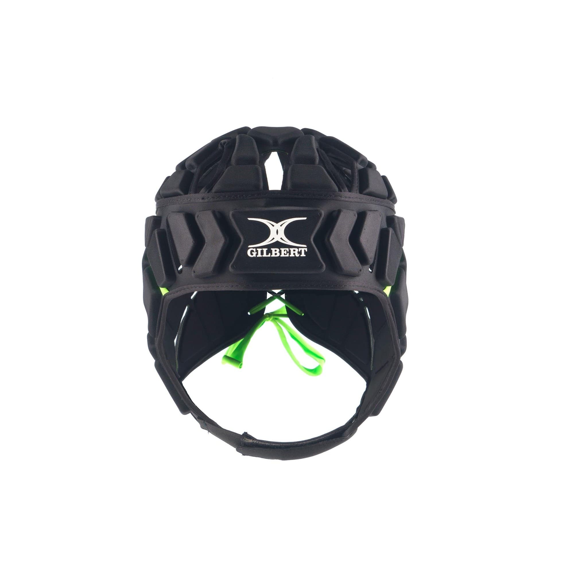 Black rugby headguard with a padded exterior, featuring a prominent white Gilbert logo on the front and adjustable green straps for a secure fit.