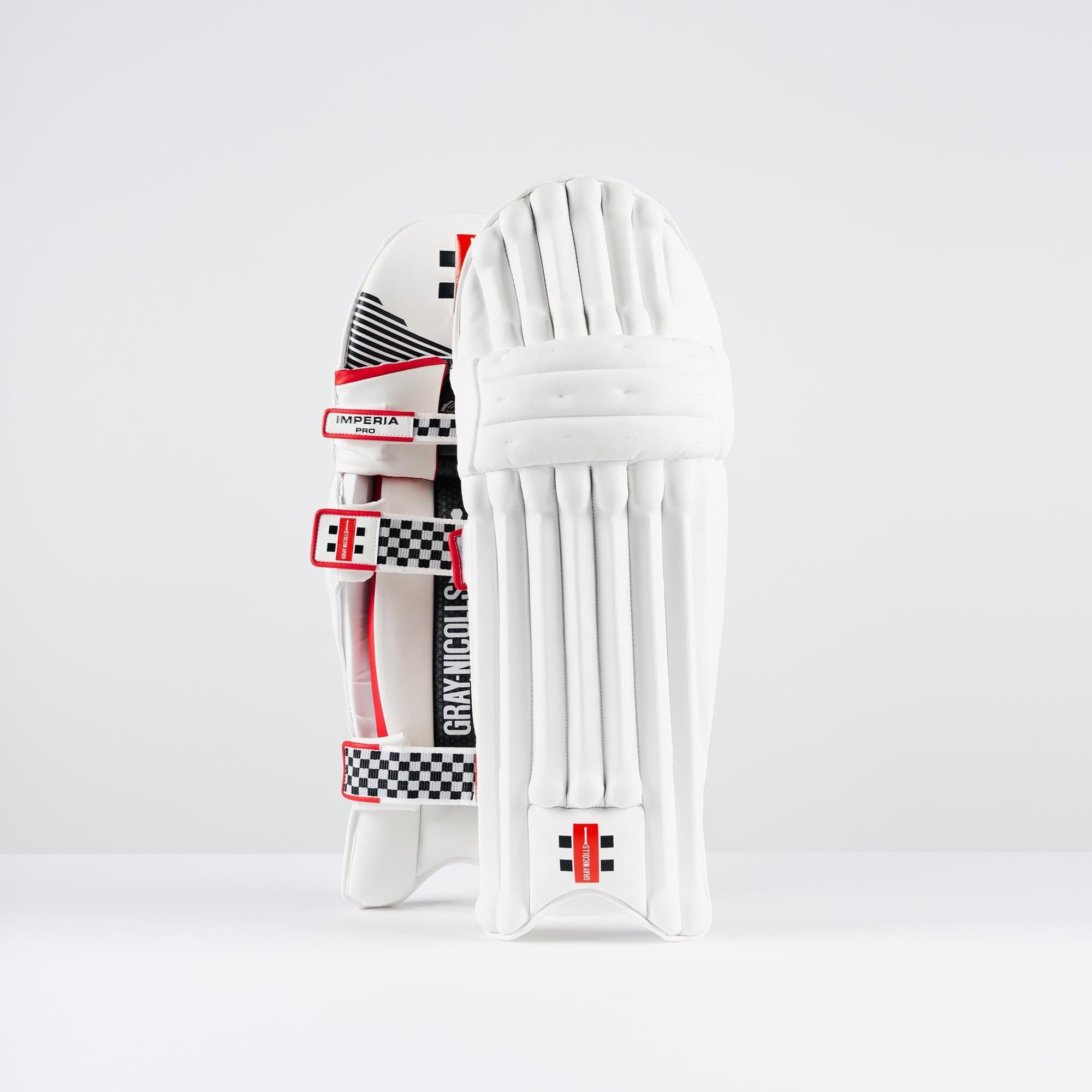 White Gray-Nicolls Imperia 1.0 Pro batting pads featuring a sleek design, red and black accents, and adjustable straps for a secure fit.