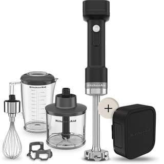 Cordless black KitchenAid hand blender with stainless steel blending arm, whisk attachment, measuring cup, chopper, and battery charger included.