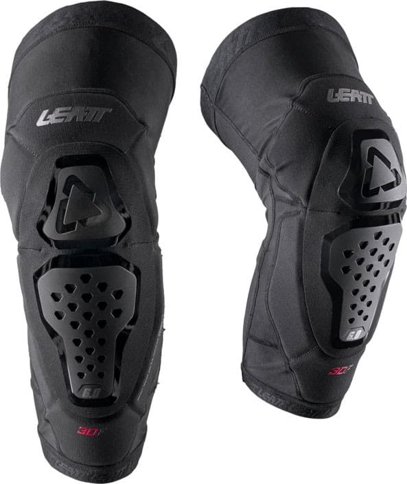 Black Leatt Evo 6.0 knee guards with hard plastic protective shells, ventilation holes, and padded fabric for comfort, designed for enhanced mobility and impact resistance.