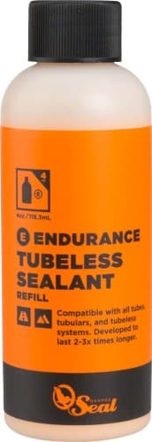 Orange Seal Endurance Sealant Refill in a 4oz bottle, featuring a bright orange label with black text, designed for tubeless tire systems and compatible with various tubes.