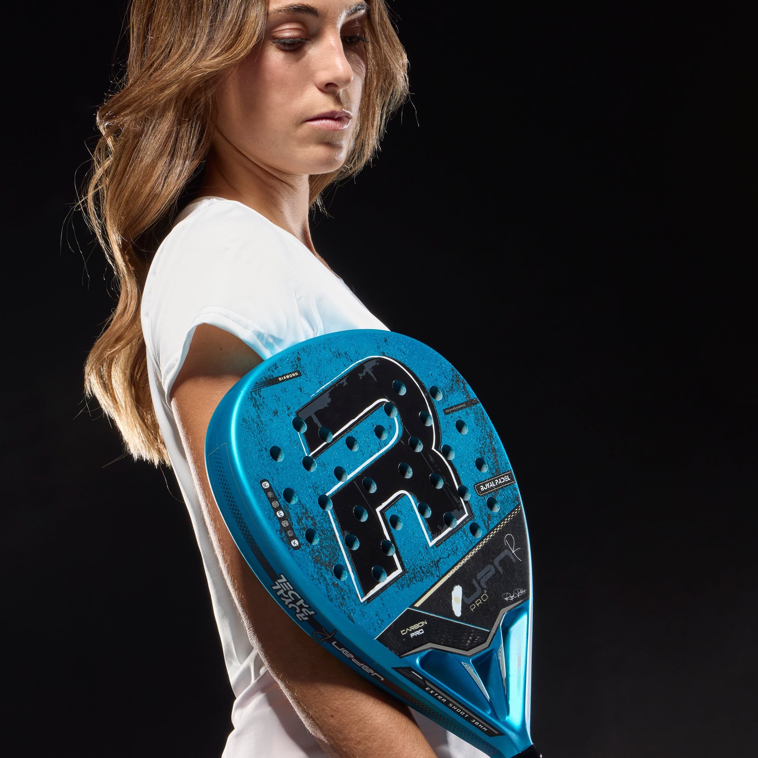 Limited edition R Pro Japan Blue padel racket by Royal Padel, featuring a striking blue color, textured surface, and prominent "R" logo, held by a player in a white shirt.